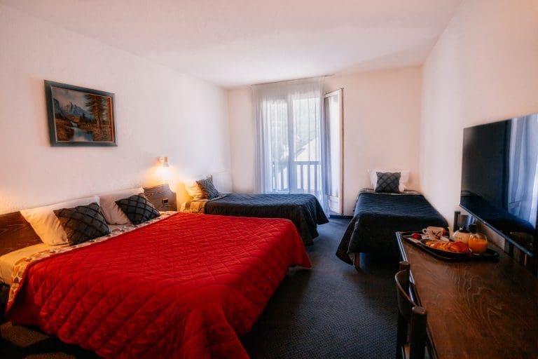 Chambre familiale spacieuse avec plusieurs lits à l'Hôtel Le Montaigu